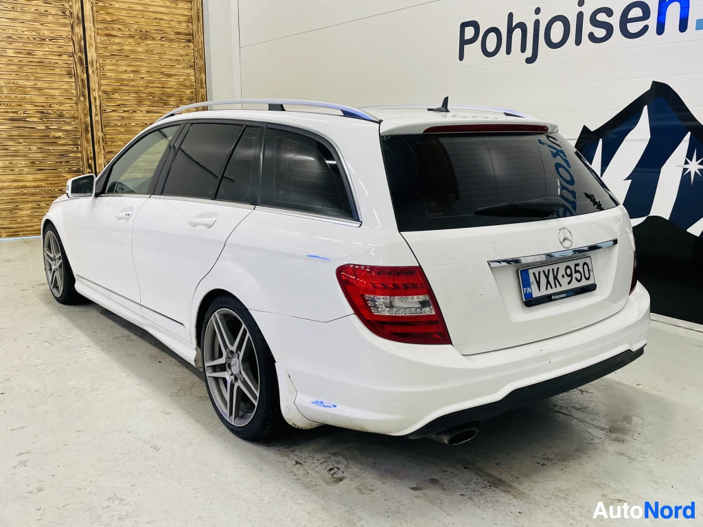 Takaviisto: Valkoinen Mercedes-Benz C-sarjan farmari takaviistosta oikealta, tummat ikkunat ja hopeiset vanteet.
