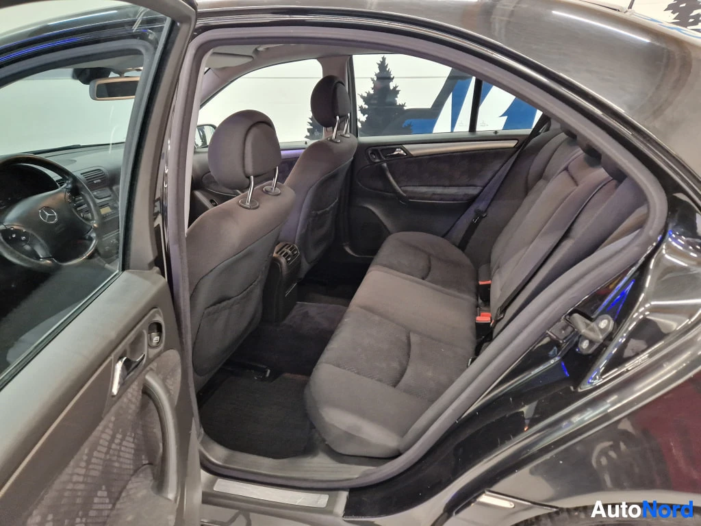 Muu: Mercedes-Benzin takapenkku ja avattu oikea takaovi, tummaa kangasverhoilua.