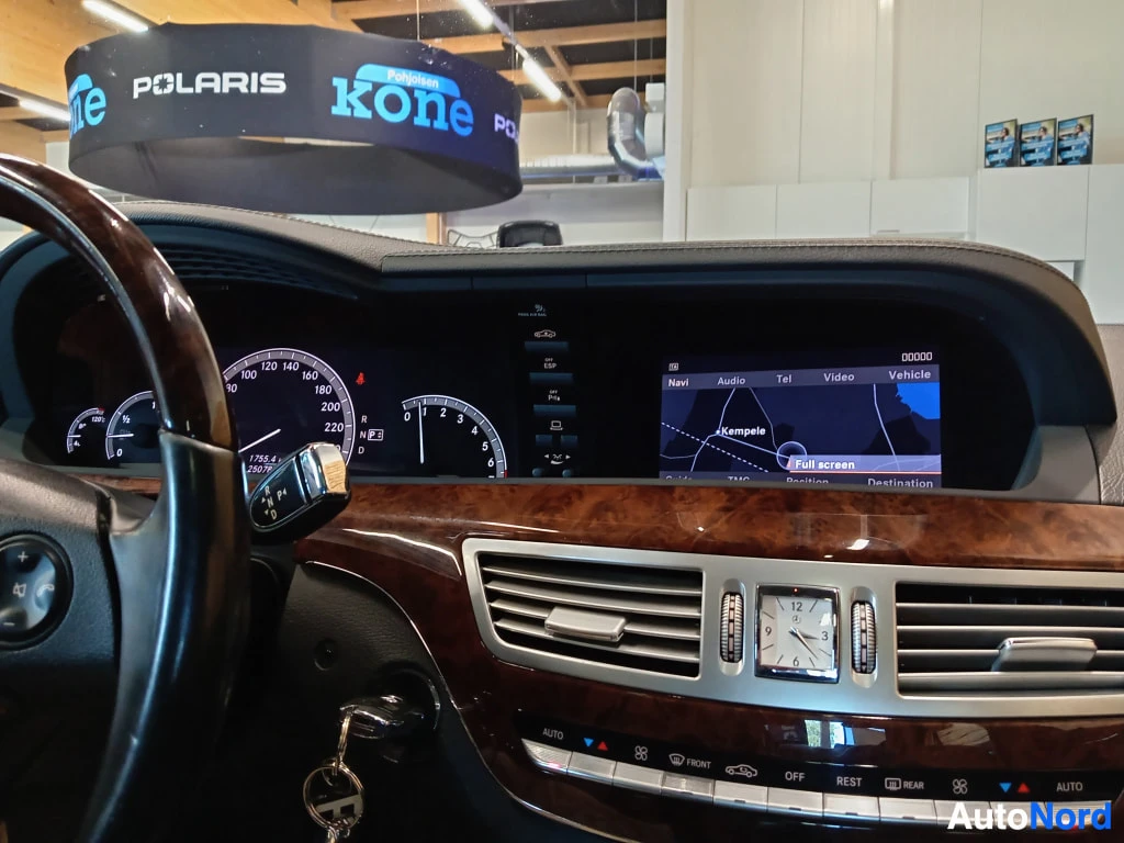 Muu: Mercedes-Benzin kojelauta: mittarit näkyvät vasemmalla ja keskellä infotainment-näyttö, jolla valikot Navi, Audio, Tel, Video ja Vehicle sekä kartta, jossa luke
