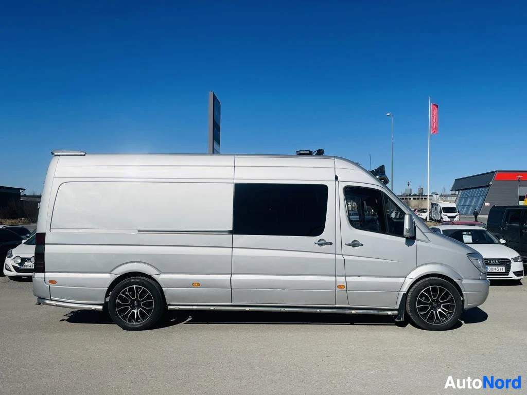 Sivulta: Hopeanvärinen Mercedes-Benz Sprinter -pakettiauto sivuprofiilista, tummat ikkunat ja mustat kevytmetallivanteet.