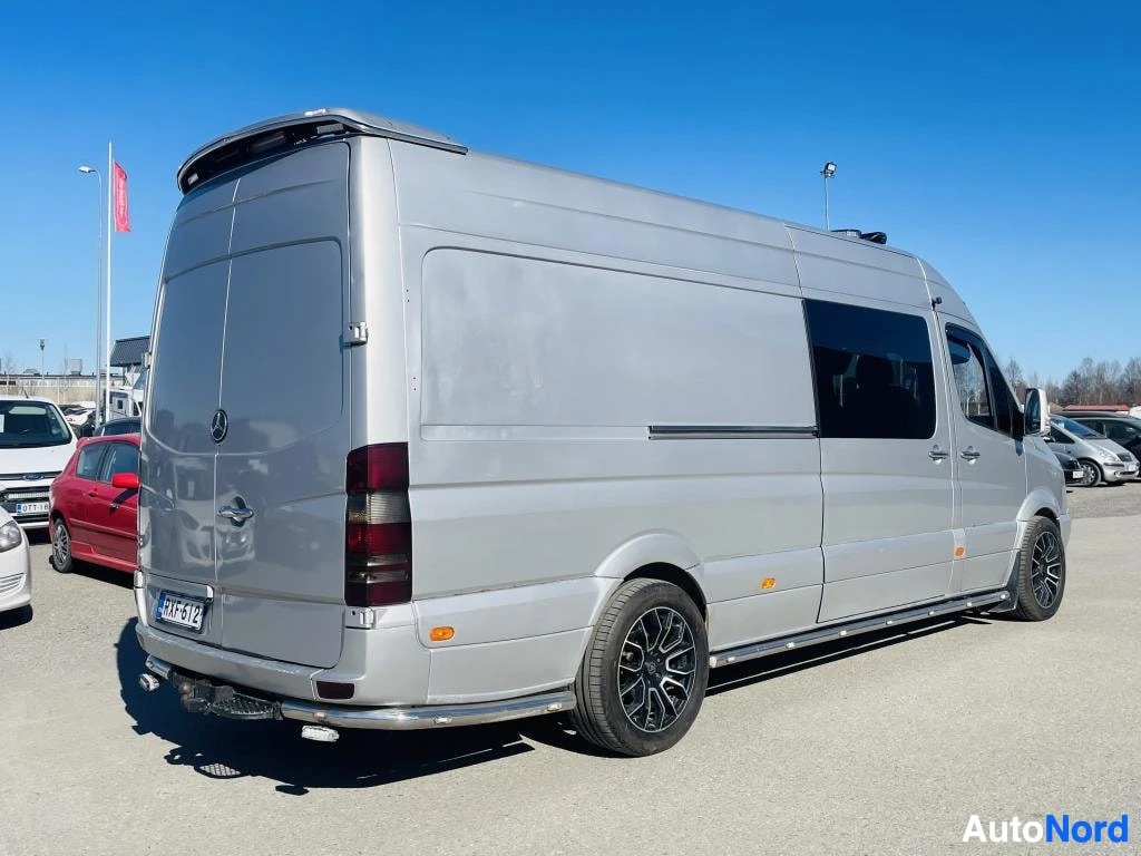 Takaviisto: Takaviistokuva Mercedes-Benz Sprinter -pakettiautosta sivulta; pitkä korikori, tummat kevytmetallivanteet ja takapuskissa suojakaari.