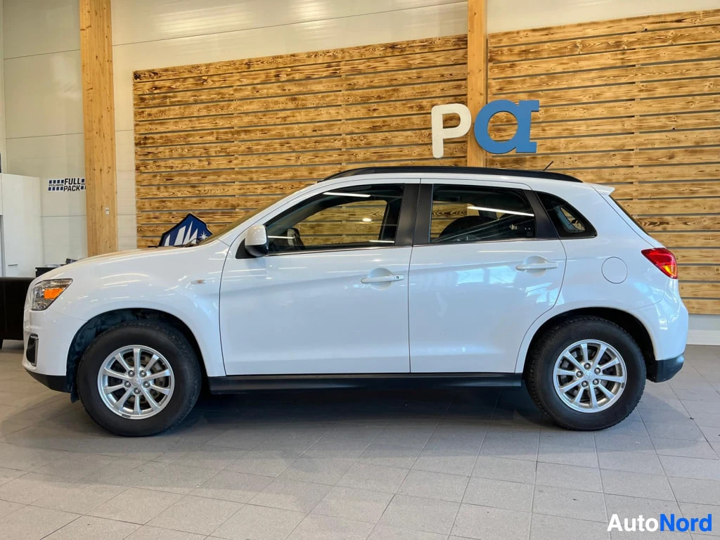 Etuviisto, nokka vasemmalle: Valkoinen Mitsubishi ASX -maasturin kylki ja keula sisätiloissa.