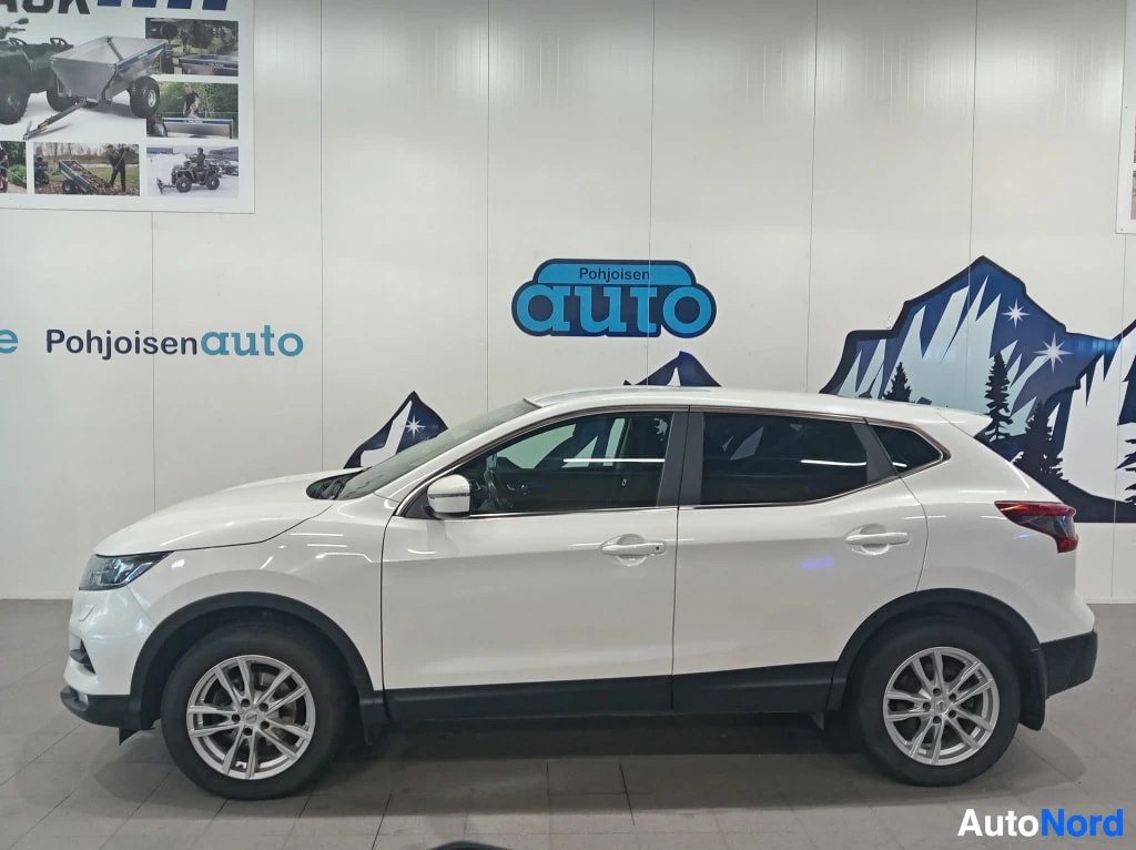 Sivulta: Valkoinen Nissan Qashqai sivulta oikealta katsottuna myymälätilassa.