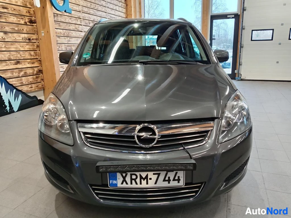 Edestä: Opel Zafiran etuosa edestäpäin; harmaa koripelti, etusäleikkö ja rekisterikilpi.