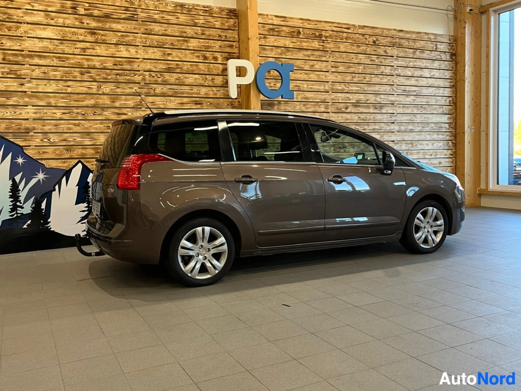 Takaviisto: Ruskea farmariauton takakulma sisätiloissa, takaosa ja kylki näkyvissä.