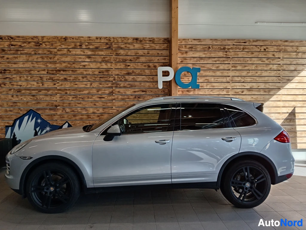 Sivulta: Porsche Cayenne -maasturin sivukuva, hopea koriväri, tummat kevytmetallivanteet ja kattokaiteet.