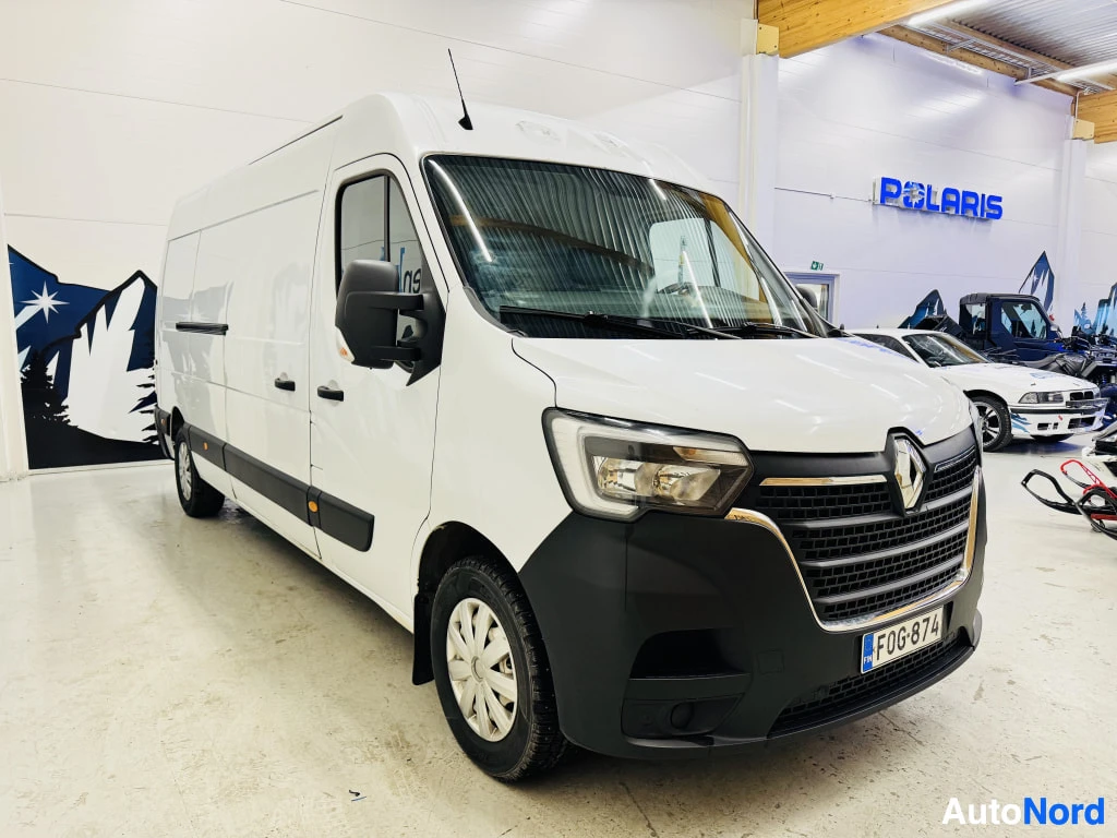 Etuviisto, nokka oikealle: Valkoinen Renault Master -pakettiauto etukulmasta sisätiloissa.
