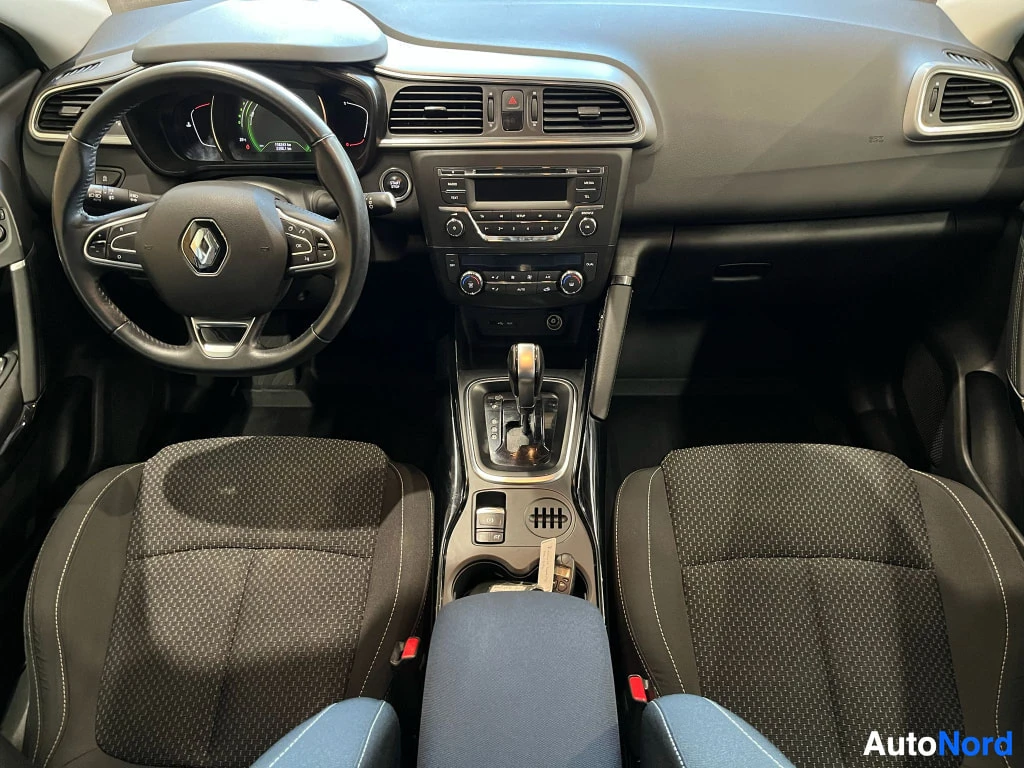 Edestä: Renault-korin sisätila ohjaamosta: ohjauspyörä vasemmalla, automaattivaihteen valitsin keskikonsolissa, kaksi etuistuintä.
