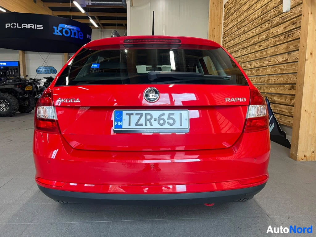 Takaa: Punainen Škoda Rapid suoraan takaa, takaluukussa ŠKODA- ja RAPID-tekstit sekä -kilpi