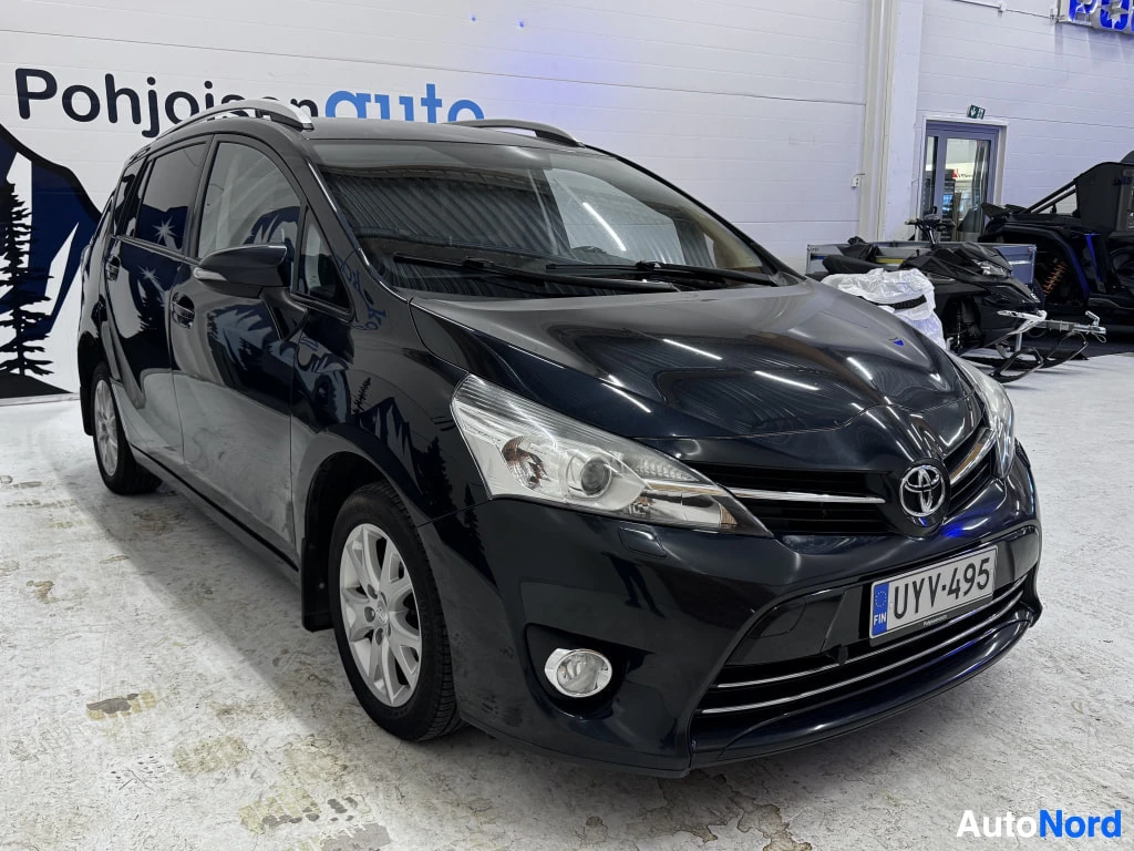 Etuviisto, nokka oikealle: Mustan Toyota Verson etukolmisivu, keulan kohdalla etupyörä ja takapyörä vasemmalla — keula oikealla.