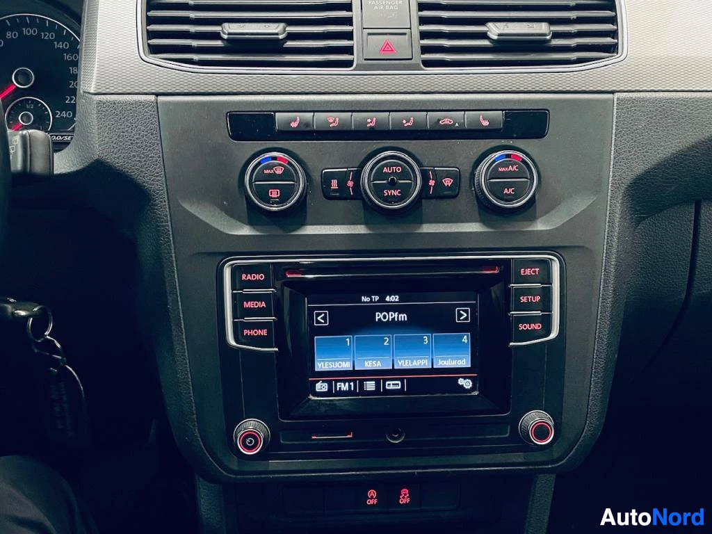 Muu: Kojelaudan keskusta: ilmastointiautomaation säätimet (AUTO, SYNC, MAX A/C) ja radio-näyttö, jolla on käynnissä FM1-asema POPfm.