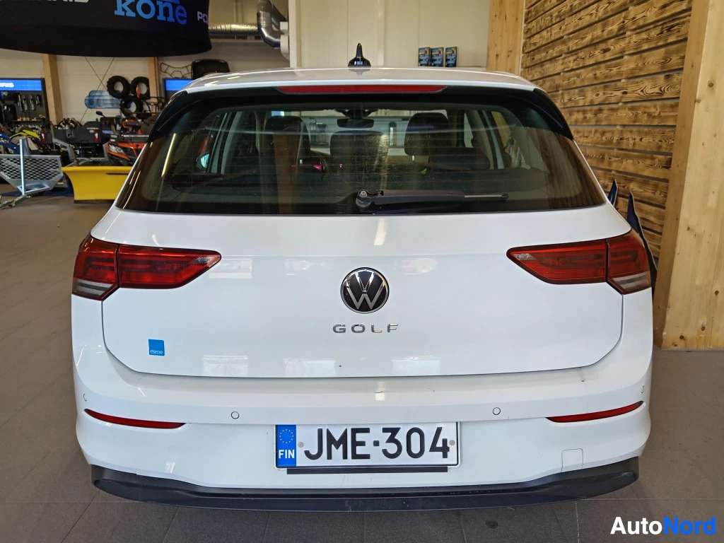 Takaa: Valkoisen Volkswagen Golf -auton takaosa sisätiloissa; rekisteritunnus, takanäkö.