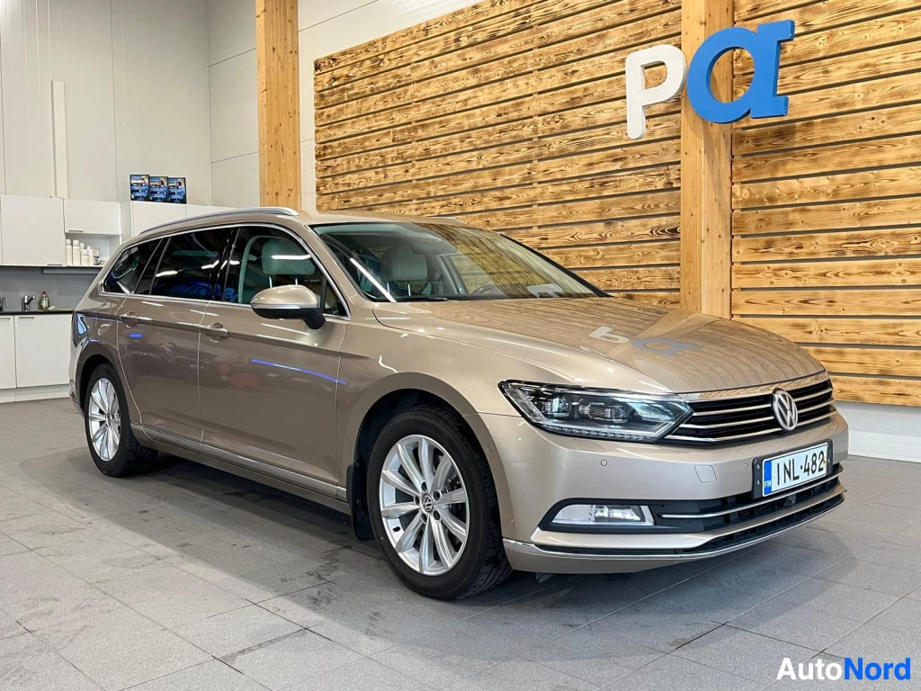Etuviisto, nokka oikealle: Volkswagenin farmariauto kolmesta neljäsosasta edestä oikealta kuvattuna sisätiloissa, rekisterikilpi.