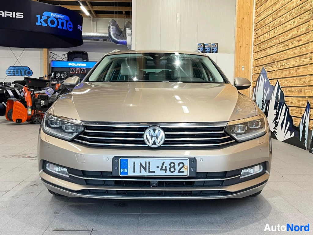 Edestä: Volkswagenin farmariauto suoraan edestä kuvattuna sisätiloissa, rekisterikilpi.