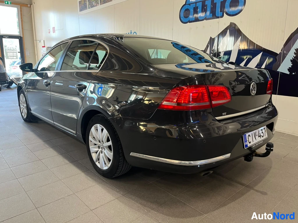 Takaviisto: Musta Volkswagen Passat -sedan takakulmasta, perävaunun vetokoukku näkyvissä, rekisterikilpi.
