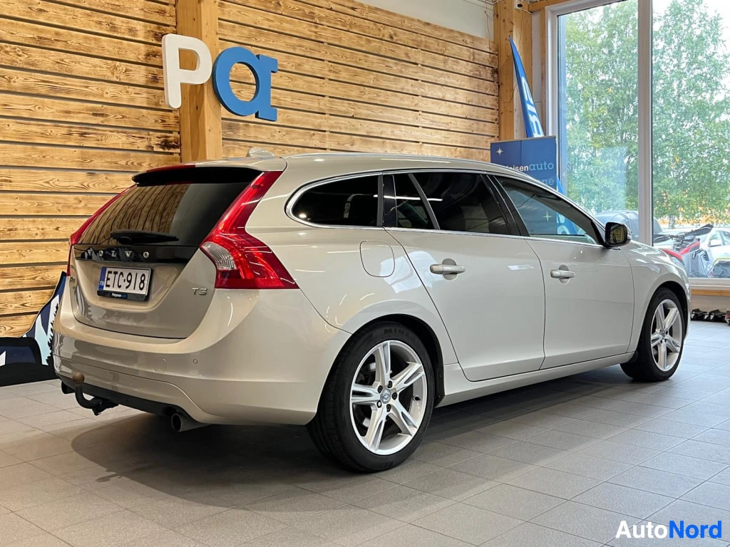 Takaviisto: Volvo V60 -farmarin takakulma sisätiloissa; rekisterikilpi, takavalot ja hinauskoukku näkyvät.