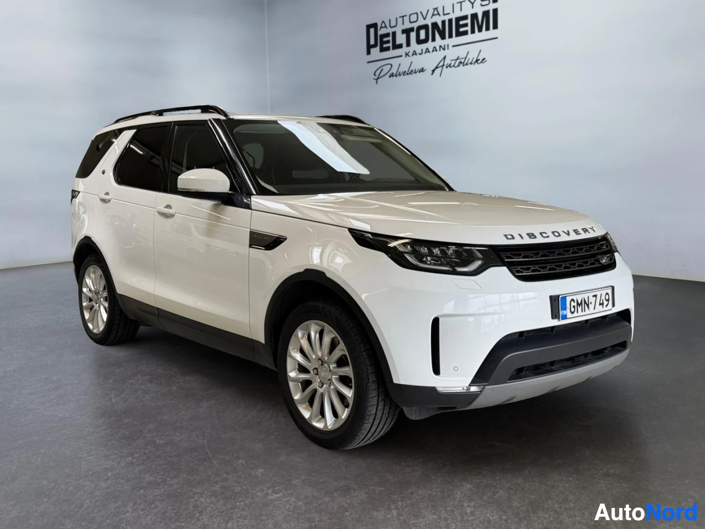 Etuviisto, nokka oikealle: Valkoinen Land Rover Discovery etukulmasta, rekisteritunnus.