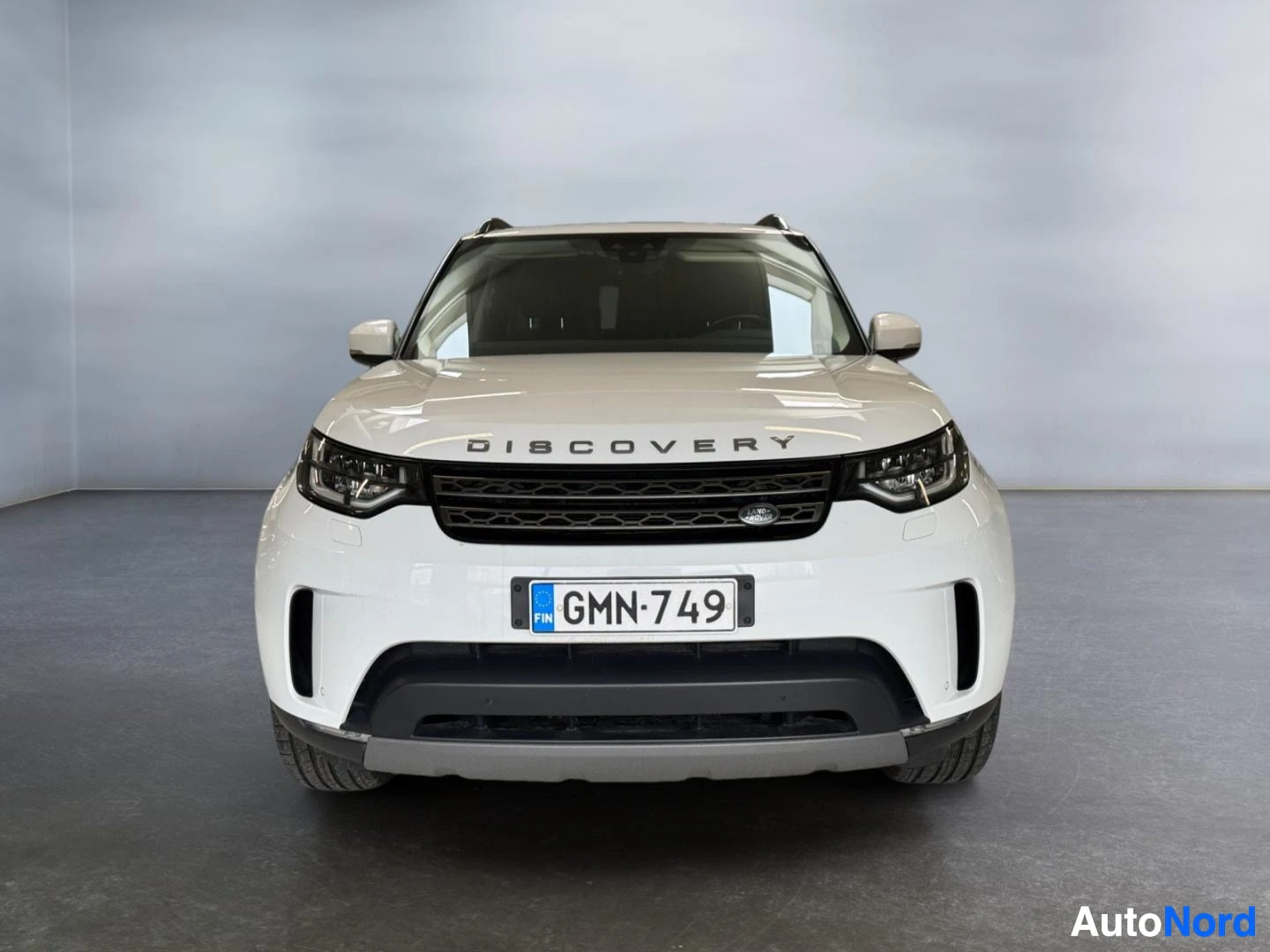 Edestä: Land Rover Discovery suoraan edestä kuvattuna, valkoinen, DISCOVERY-teksti konepellin reunassa, rekisteri.