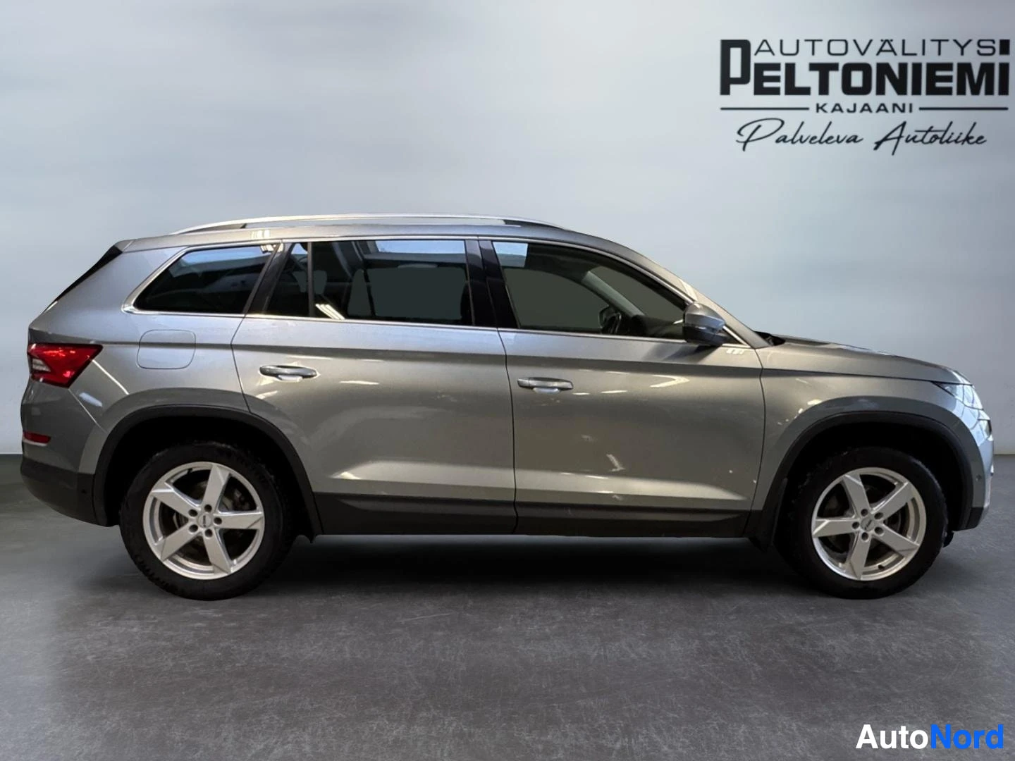 Sivulta: Skoda Kodiaq -maasturin sivukuva sisätiloissa; auton kylki on hopeanharmaa ja pyörät kevytmetallivanteilla.