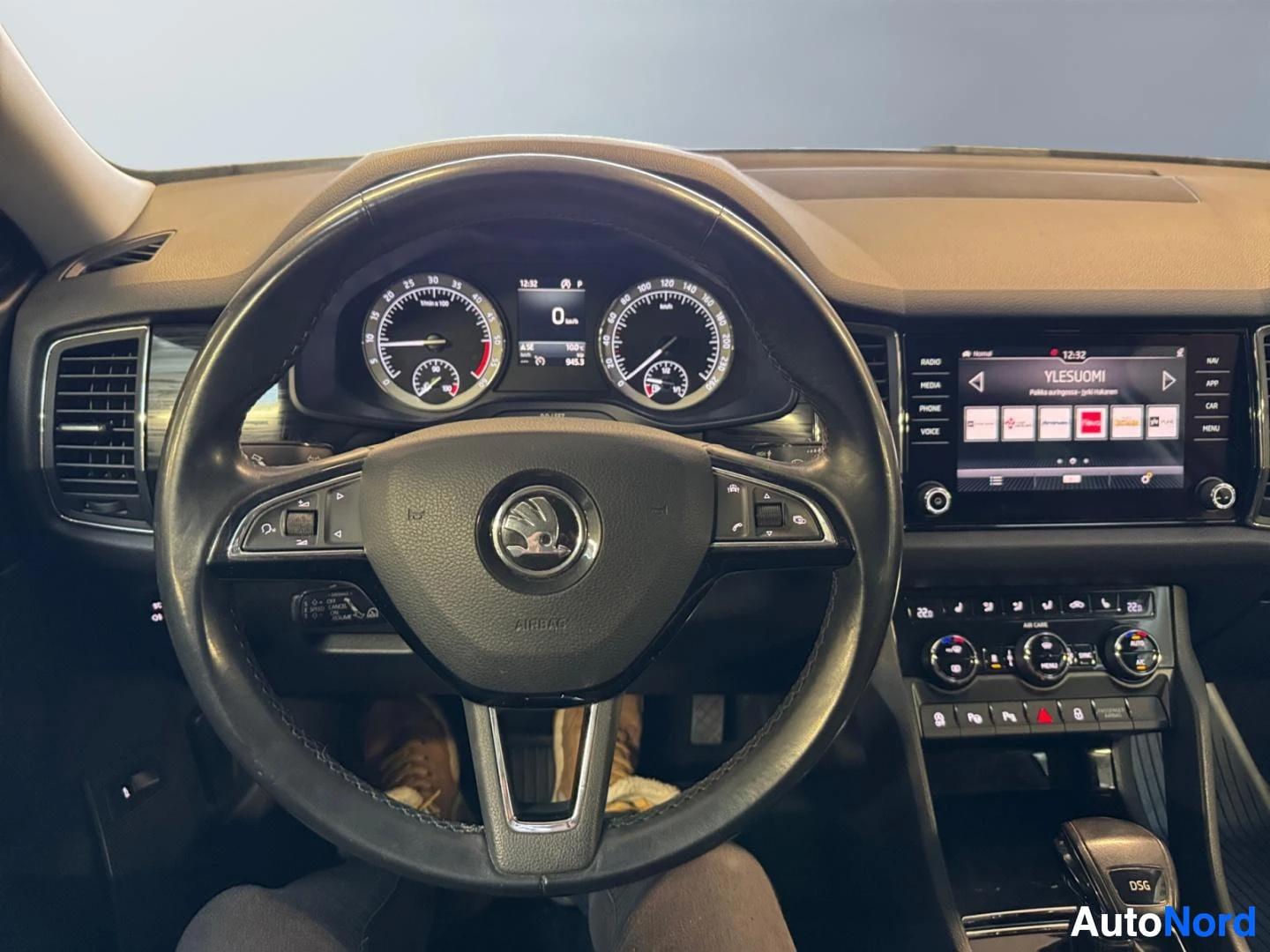 Muu: Ohjauspyörä ja kojelauta eteenpäin kuvattuna; Skoda-merkki ohjauspyörässä, infotainment-näyttö keskellä ja DSG-vaihteenvalitsin.