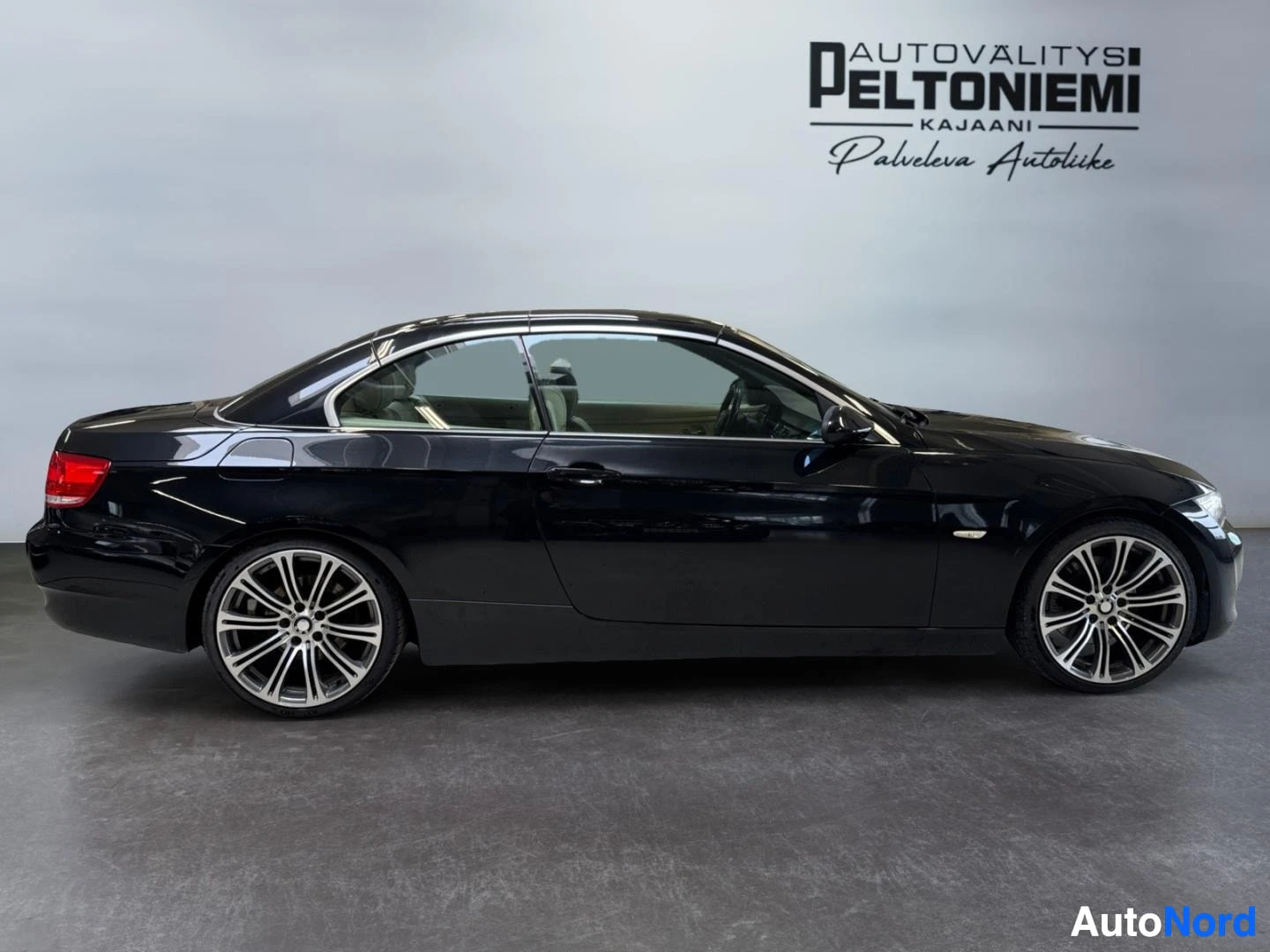 Sivulta: Mustan BMW-avomallin sivukuva suljetulla katolla sisätiloissa.