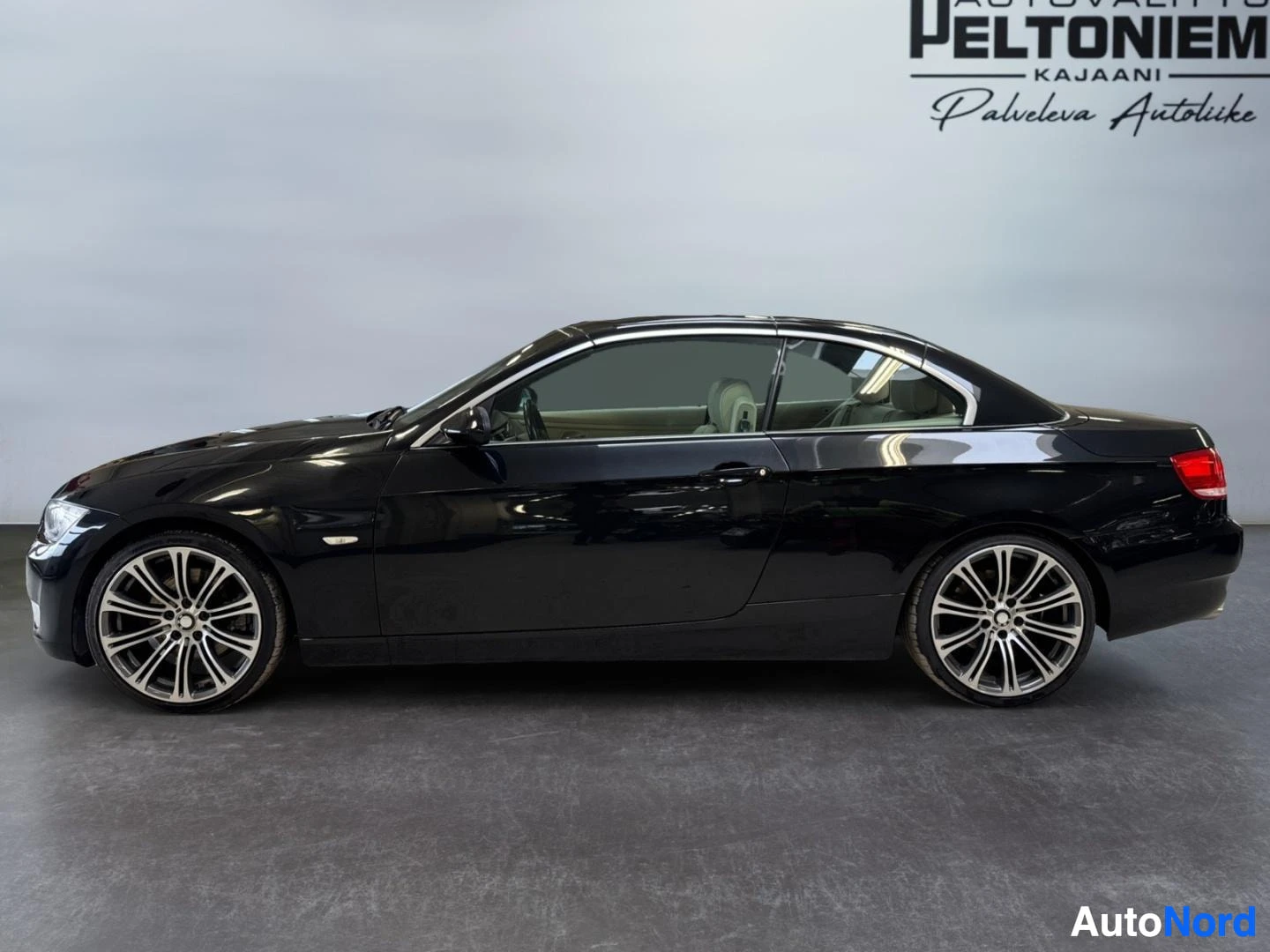 Sivulta: Mustan avoauton vasen kylki sivulta, kevytmetallivanteet, katto kiinni.