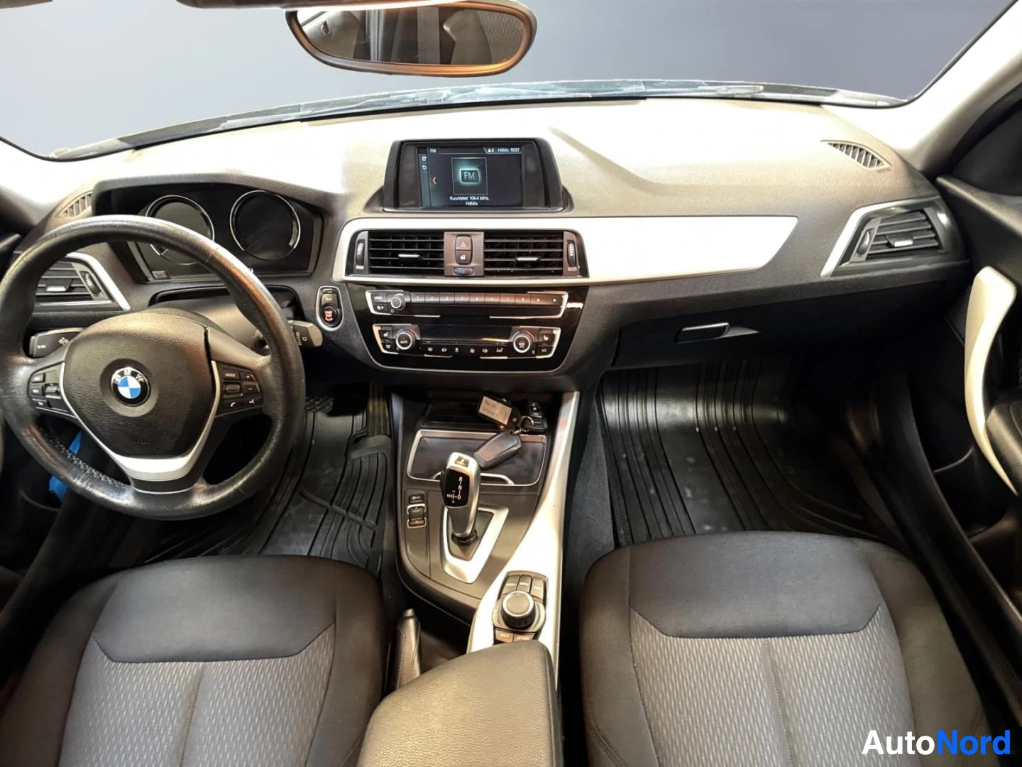 Muu: Kojelauta ja etutuolit kohtisuoraan päin: BMW-ohjauspyörä, keskikonsolissa automaattivaihteen valitsin ja ruudullinen infotainment-näyttö, sytytysavaimet kojeis