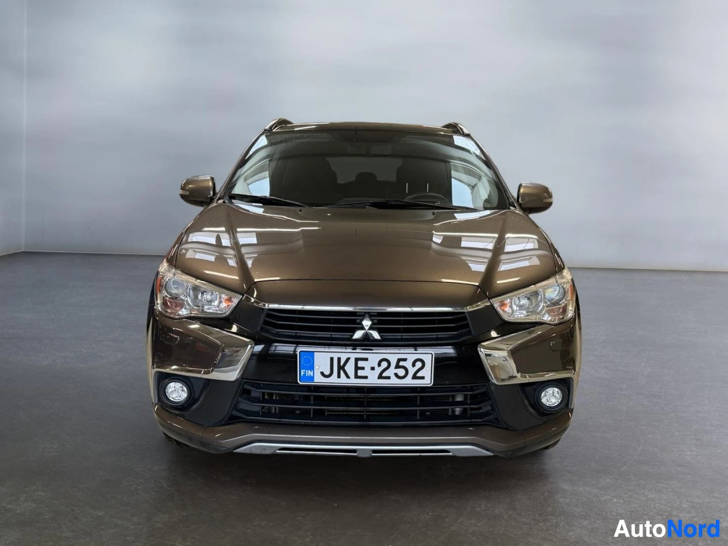 Edestä: Mitsubishi ASX suoraan edestä; täydet ajovalot ja sumuvalot, rekisteritunnus.