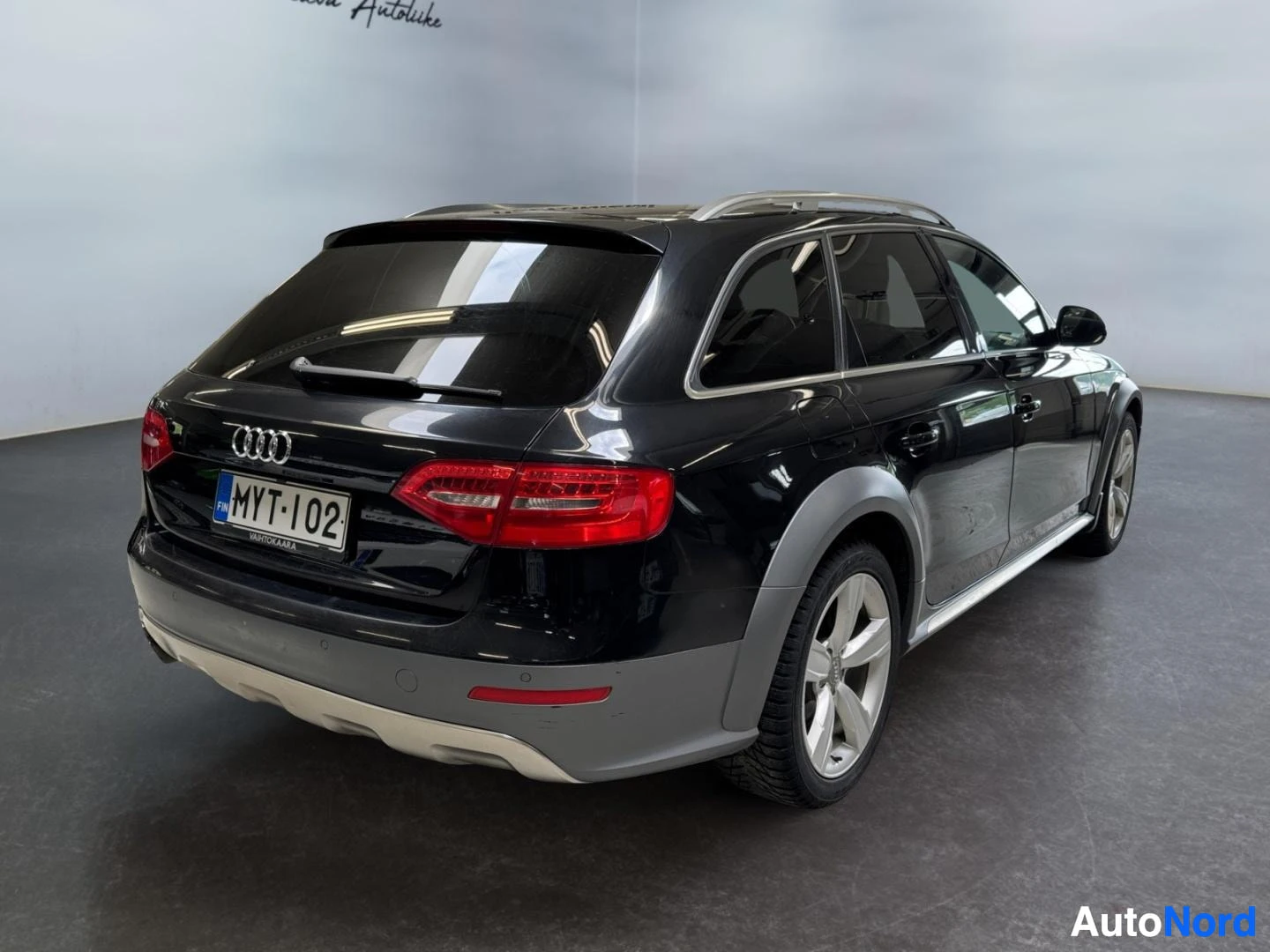 Takaviisto: Musta Audi A4 Allroad takaa kolmella neljäsosaa, rekisteritunnus, kattokaiteet ja hopeiset vanteet.