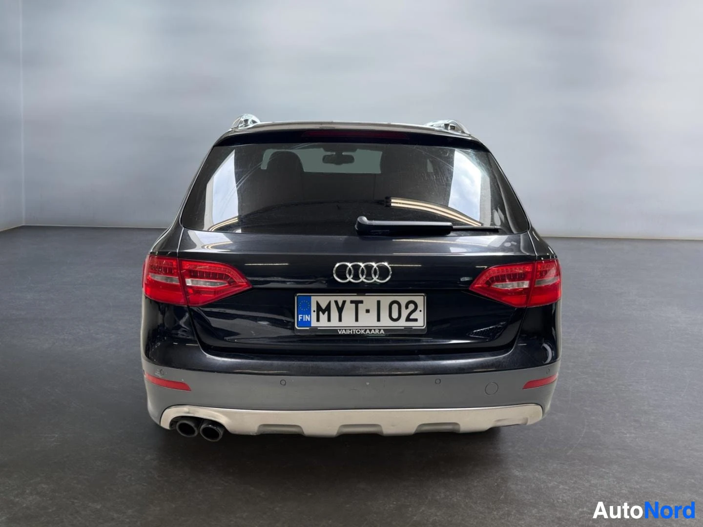 Takaa: Musta Audi A4 Allroad suoraan takaa, rekisteritunnus, kaksoispakoputket ja takalasinpyyhin.