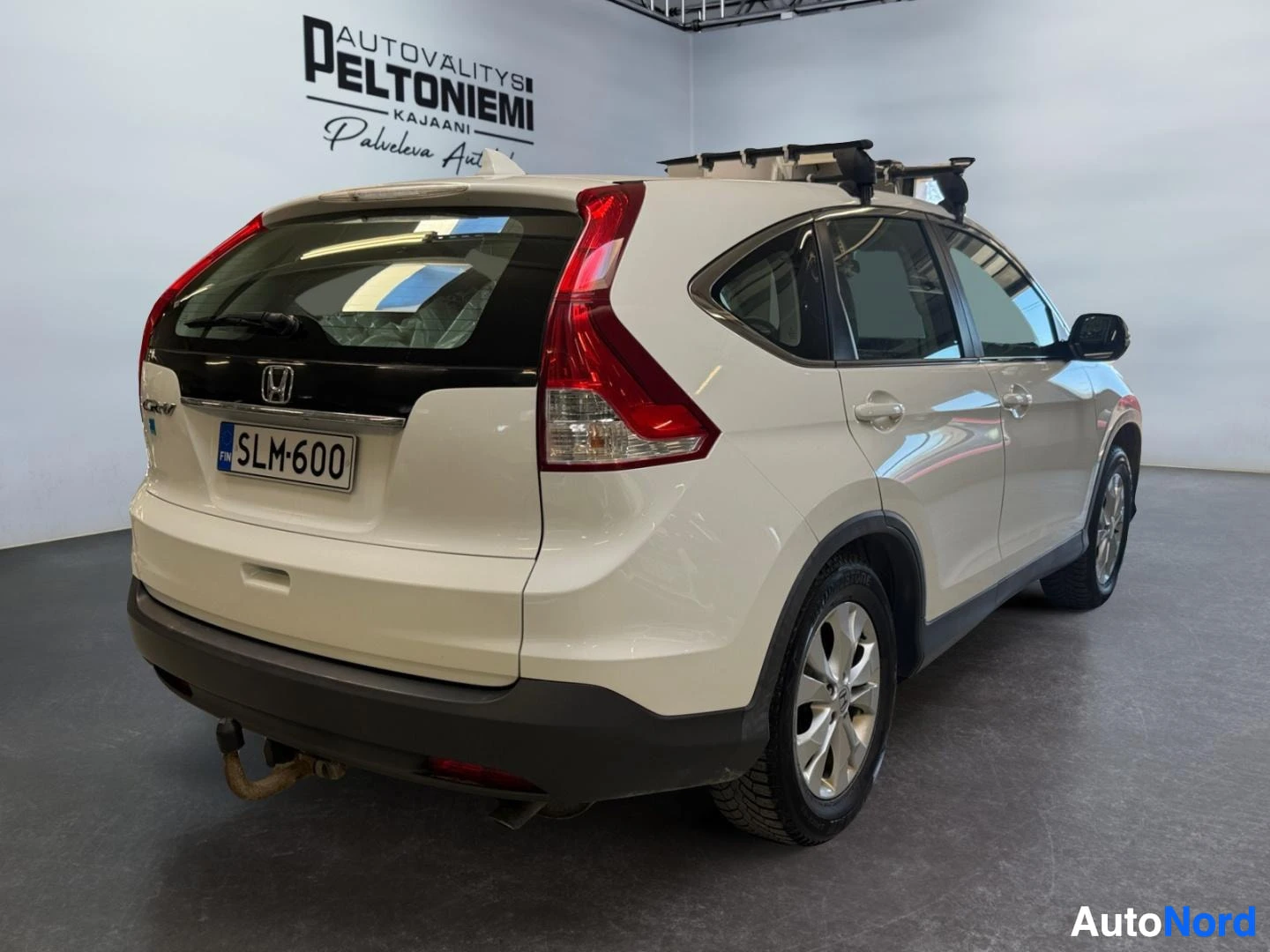 Takaviisto: Honda CR-V takakulmasta oikealta, rekisteritunnus, vetokoukku ja kattoteline näkyvissä.