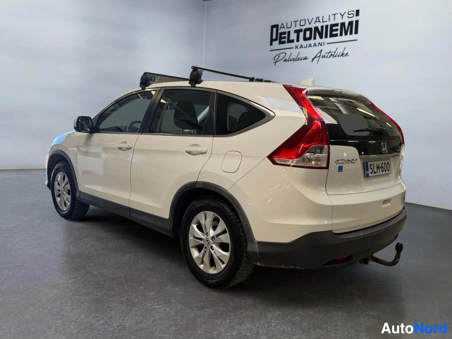 Takaviisto: Honda CR-V takaa kulmasta, valoksuvetinen, kattoteline ja vetokoukku näkyvissä.