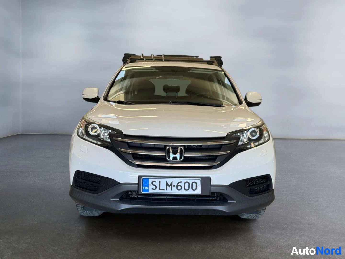 Edestä: Honda CR-V suoraan edestä, valkoinen, kattoteline katolla.