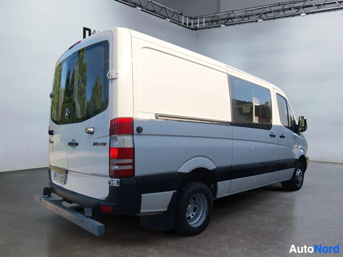 Takaviisto: Valkoinen Mercedes-Benz Sprinter -pakettiauto takaviistosta kuvattuna, 516 CDI -merkintä takapaneelissa.