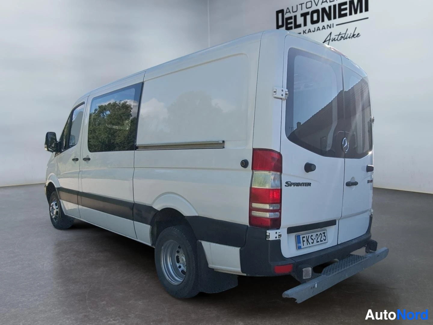 Takaviisto: Mercedes-Benz Sprinter -pakettiauto takaa kolmannelta sivulta, valkoinen kori ja tummat puskurit.