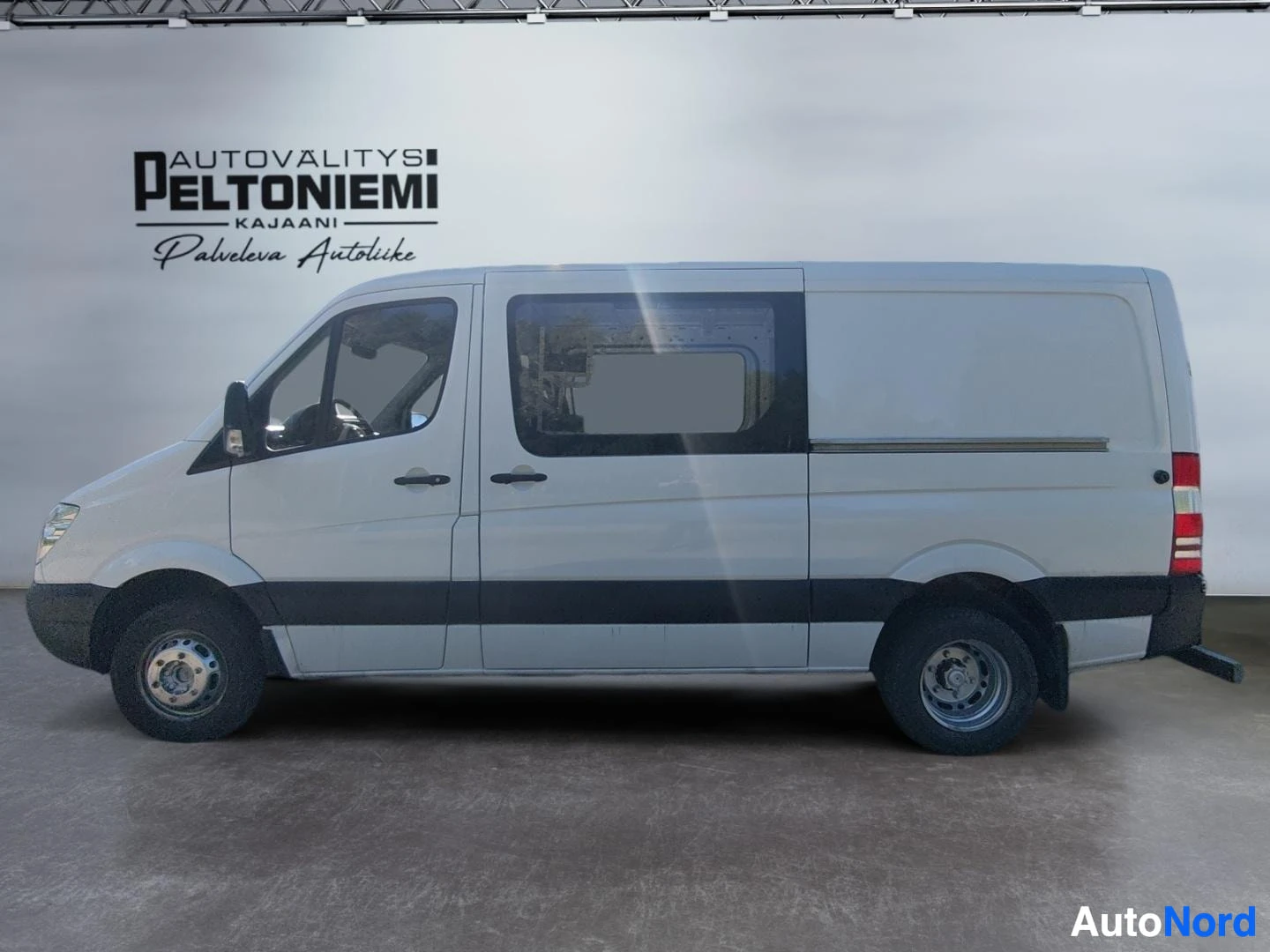 Sivulta: Mercedes-Benz Sprinter -pakettiauto sivulta, valkoinen kori ja tumma sivukoriste.