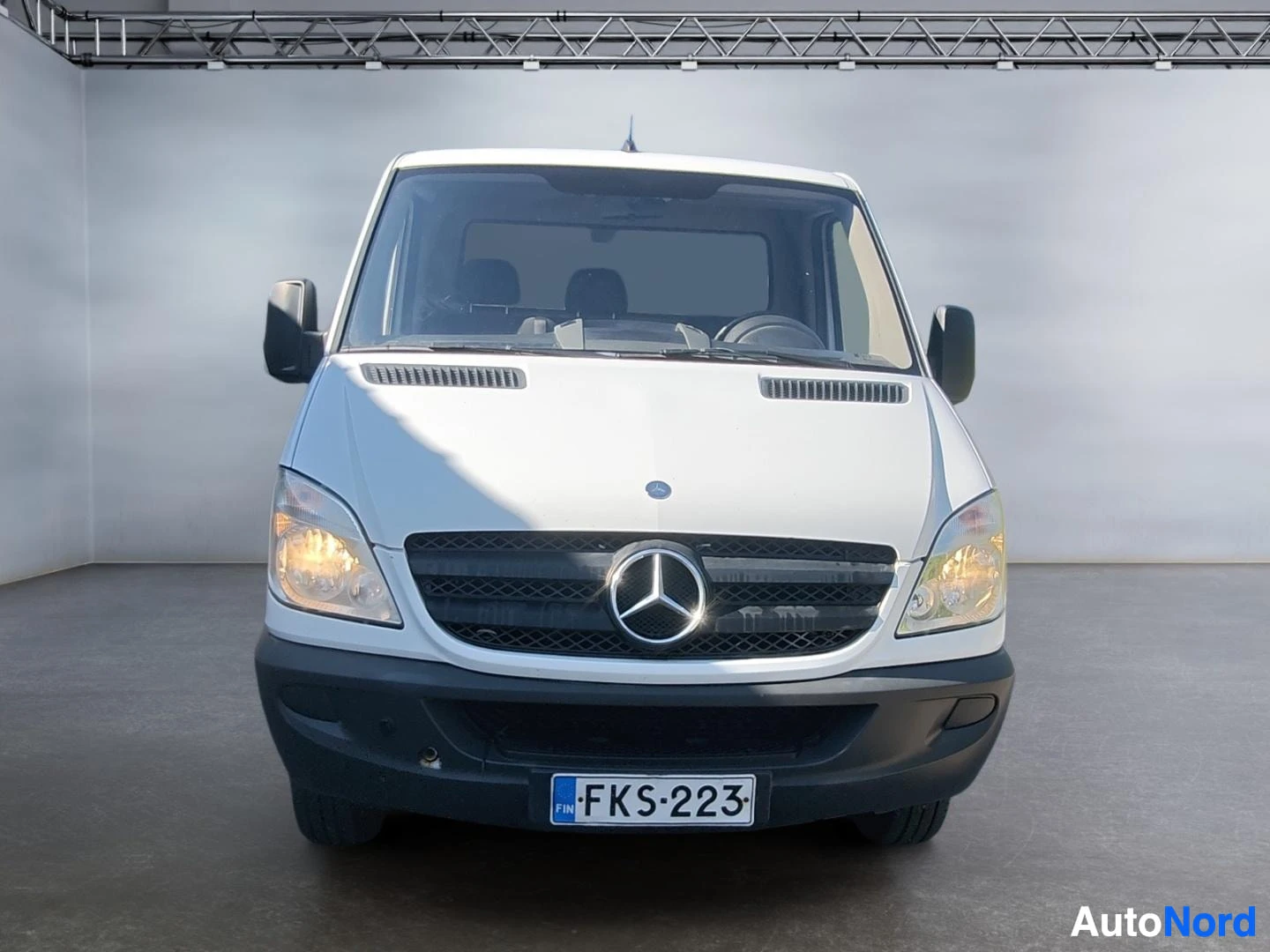 Edestä: Mercedes-Benz Sprinter -pakettiauto suoraan edestä, Mercedes-tähti etusäleikössä.