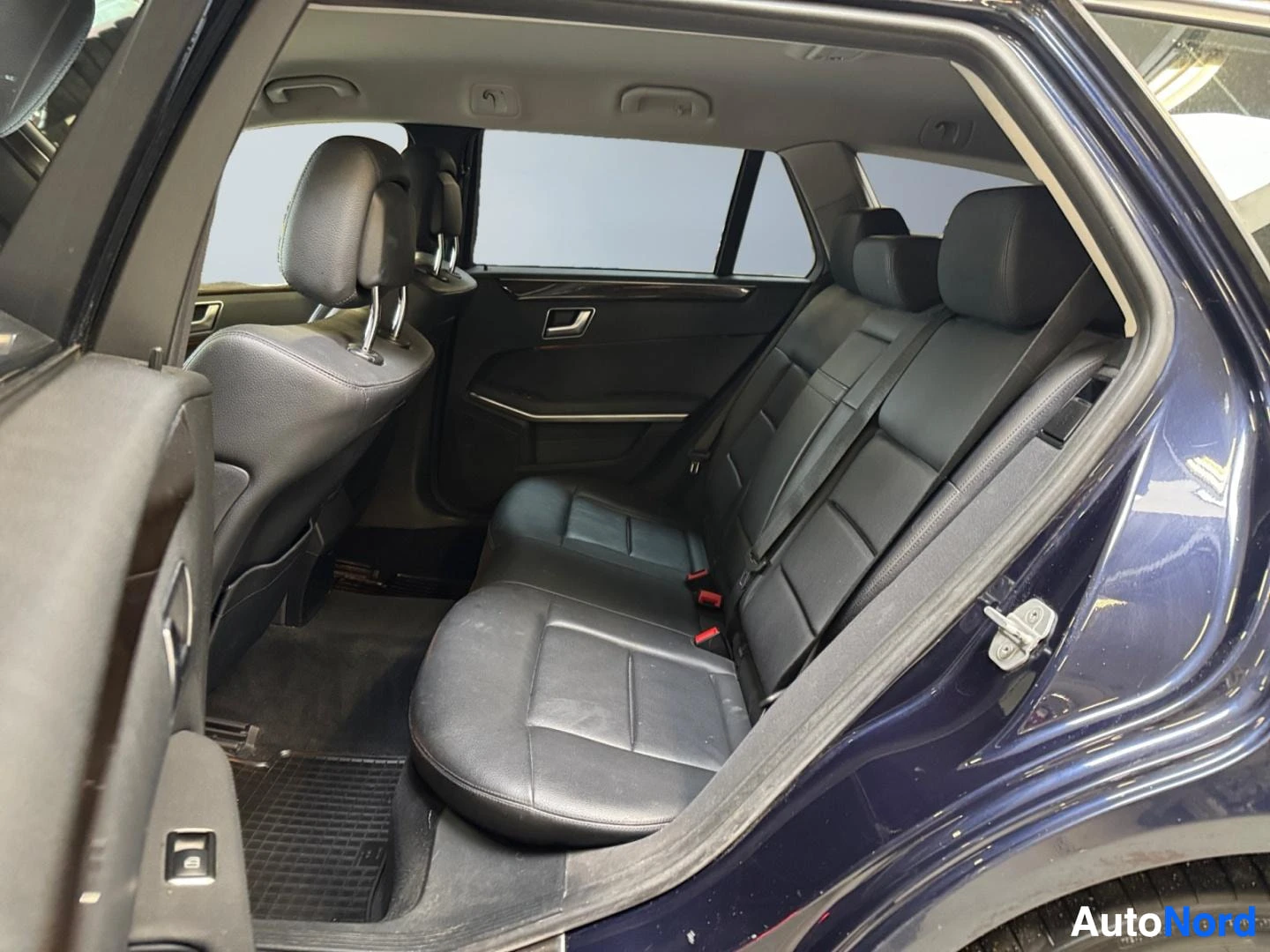 Muu: Takanapän sisäkuva avatusta takaovesta: musta jakotuoli selkänojineen ja headrest-takitilat.