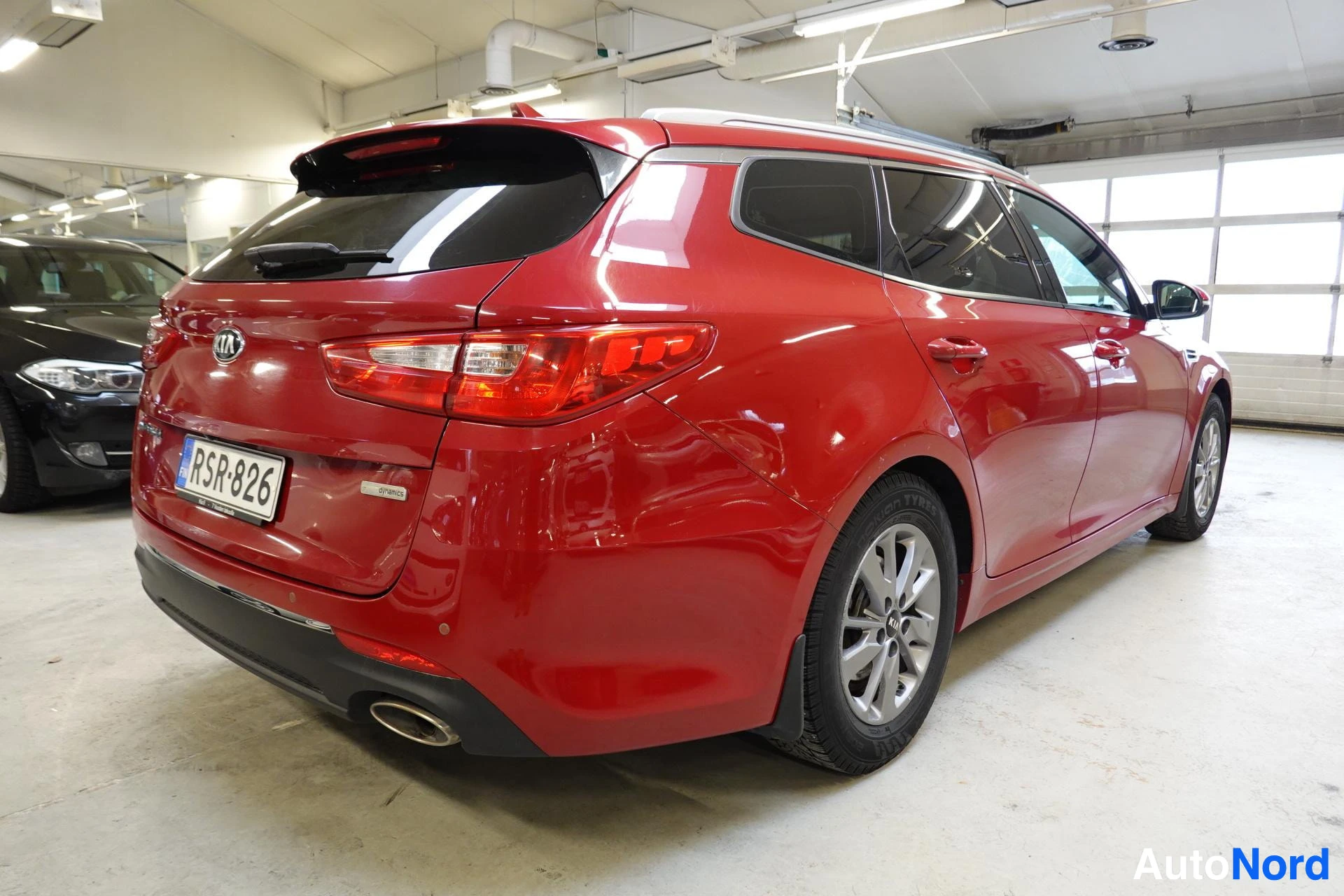 Takaviisto: Punainen Kia Optima -farmari kulmassa takaa vasemmalta, rekisteri.