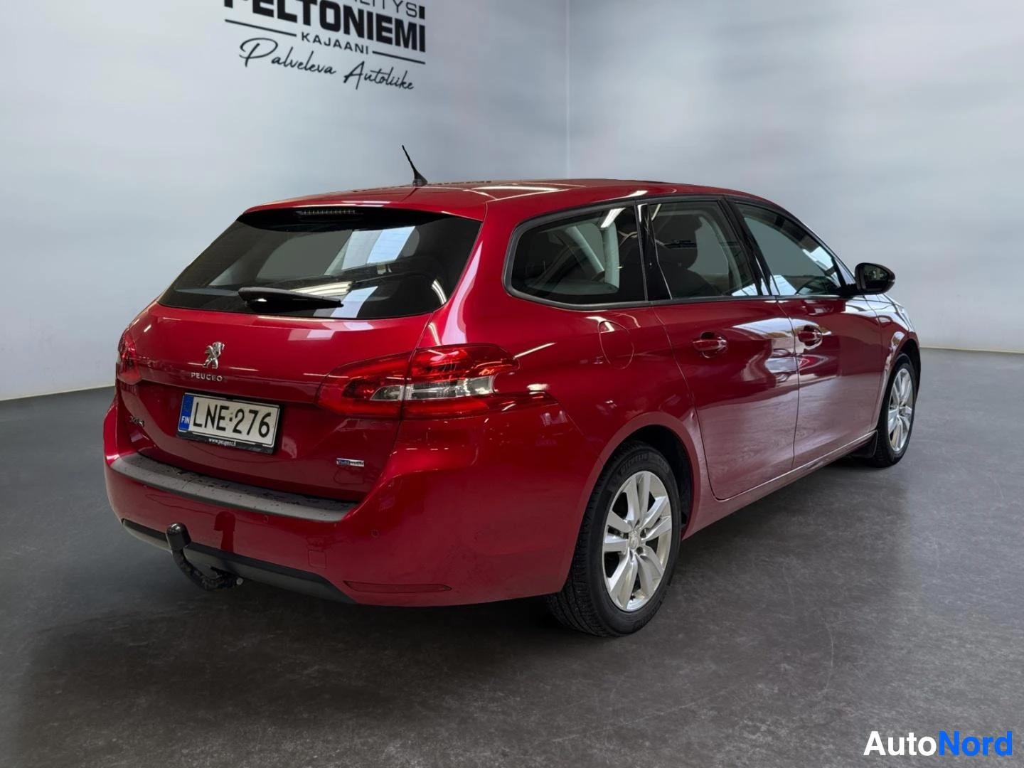 Takaviisto: Punainen Peugeot 308 SW takaviistosta kuvattuna, rekisterikilpi.