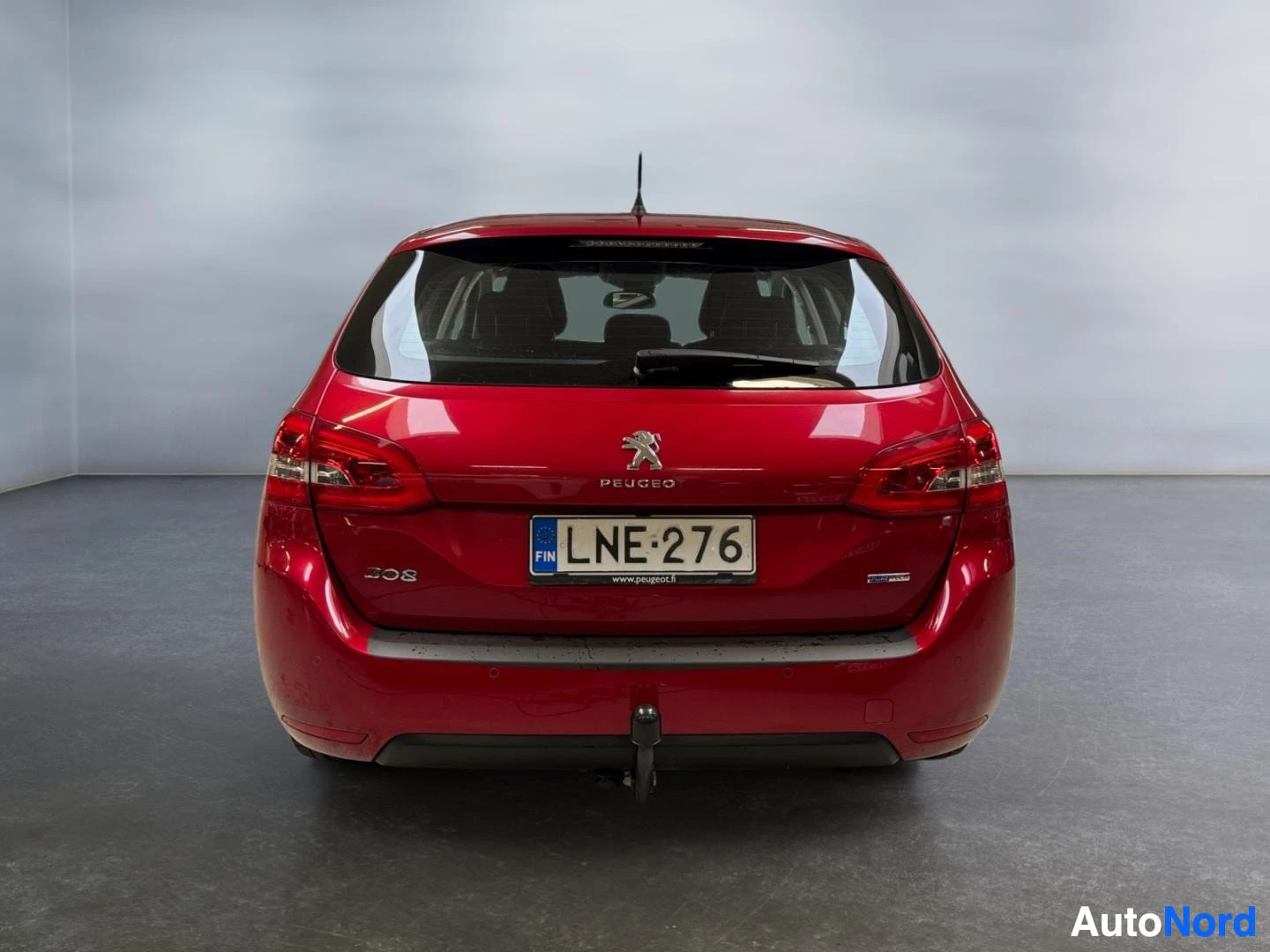 Takaa: Punaisen Peugeot 308:n takaosa suoraan takaa, rekisterikilpi ja 308-merkintä.
