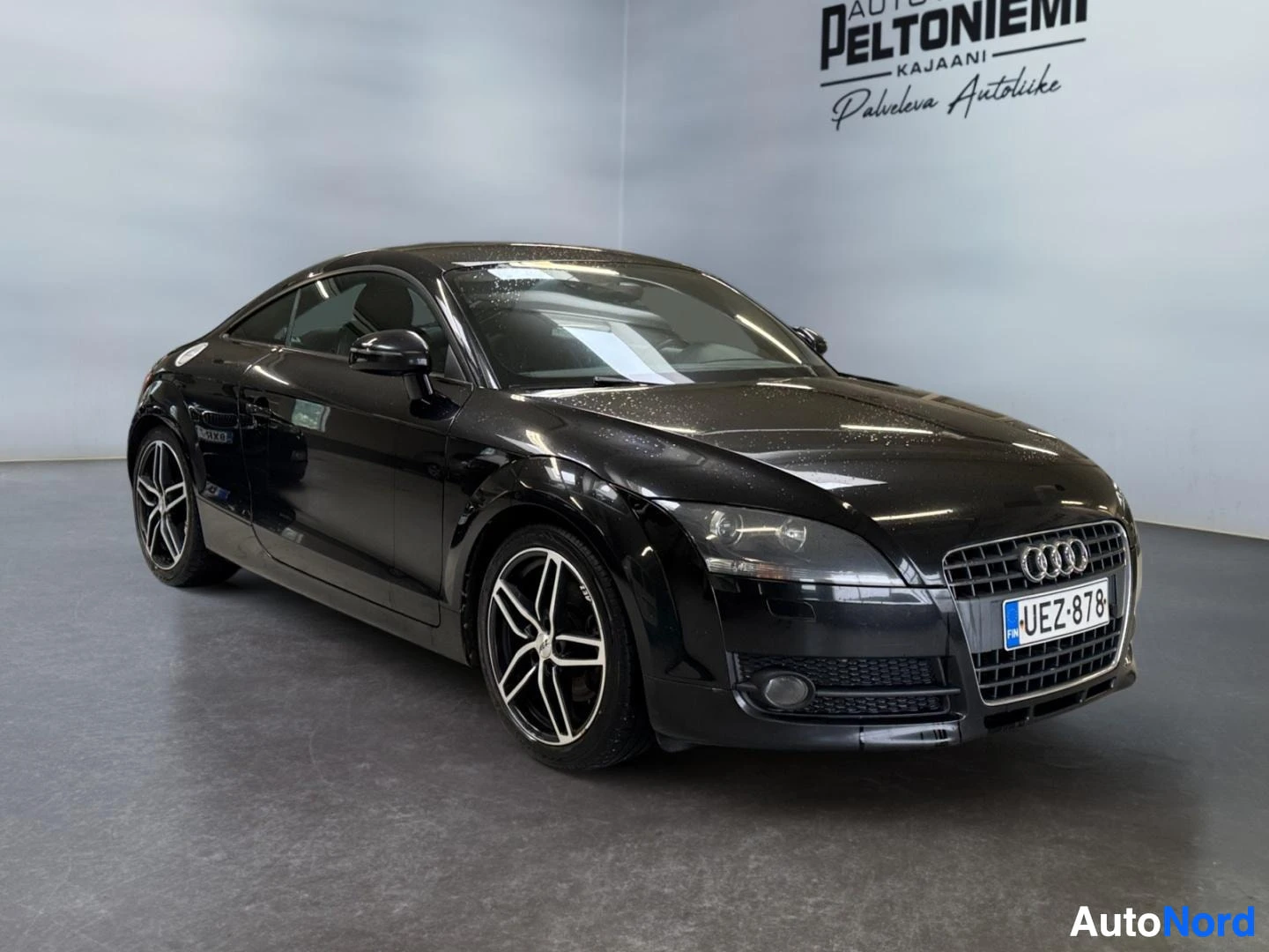 Etuviisto, nokka oikealle: Audi TT Coupé mustana etuviistosta, keulaa ja kylkeä näkyy.