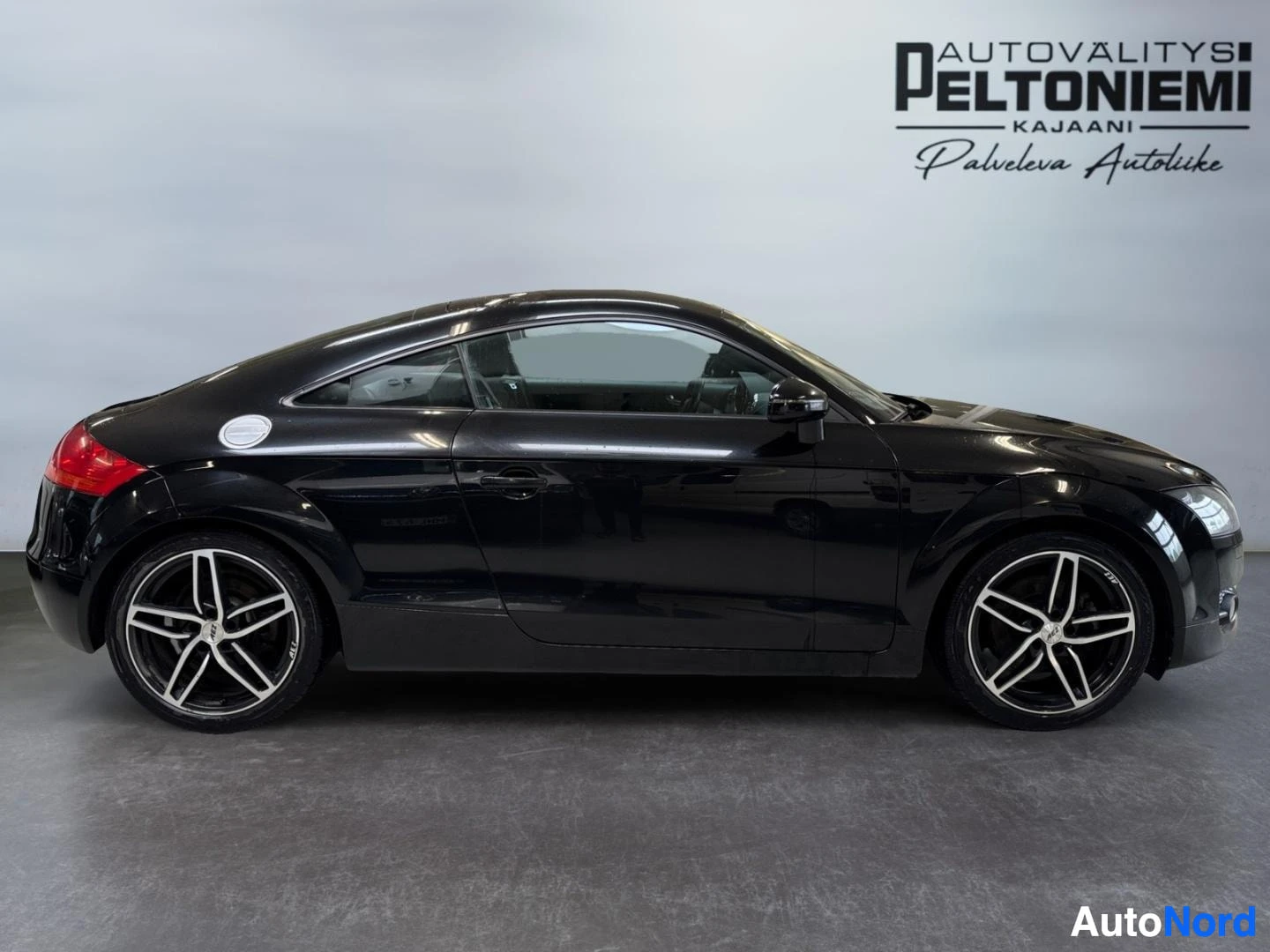Sivulta: Audi TT Coupé mustana sivulta, kylki kokonaan näkyvissä.
