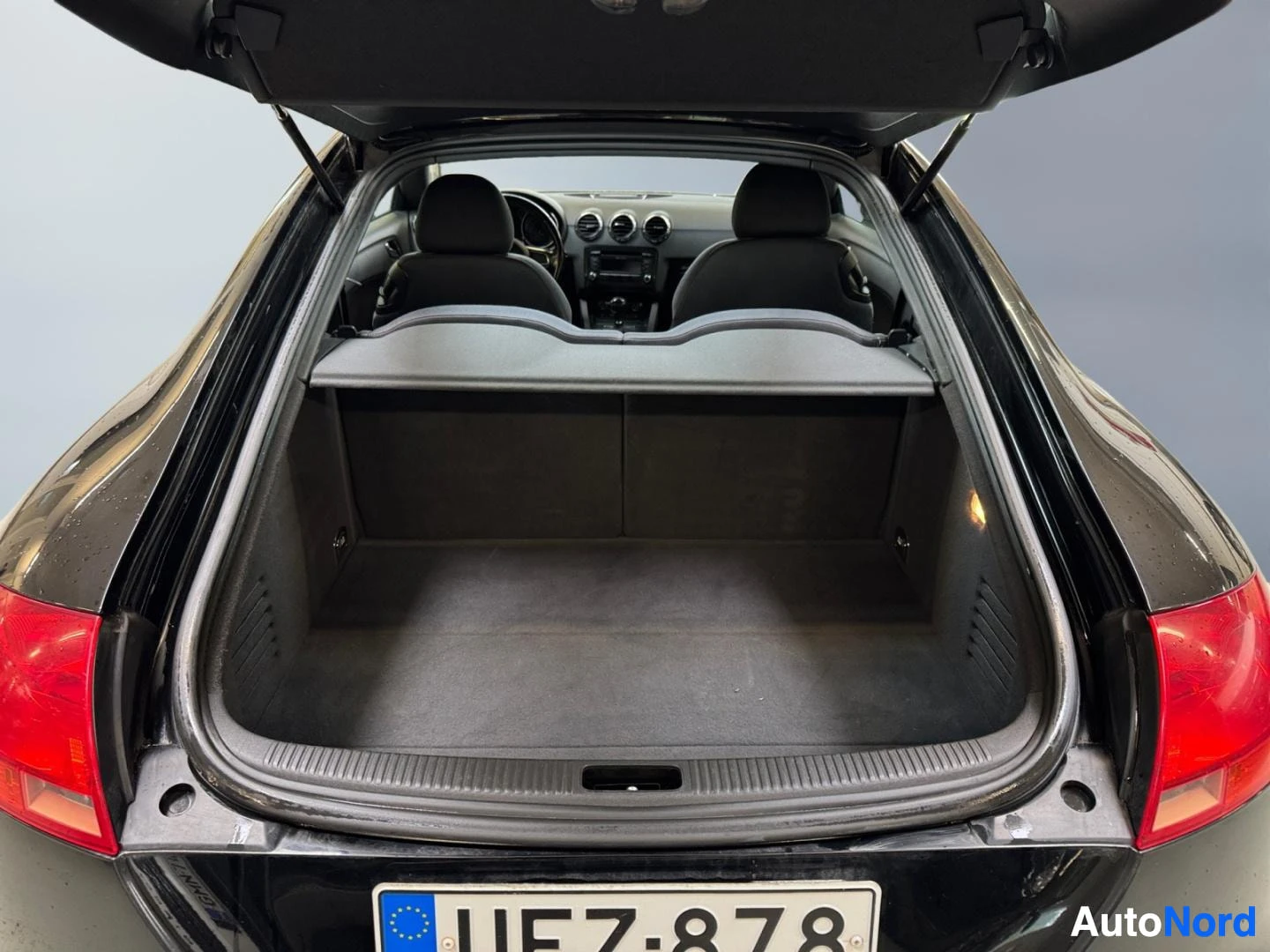 Takaa: Audi TT:n tavaratila avattuna, rekisterikilpi.