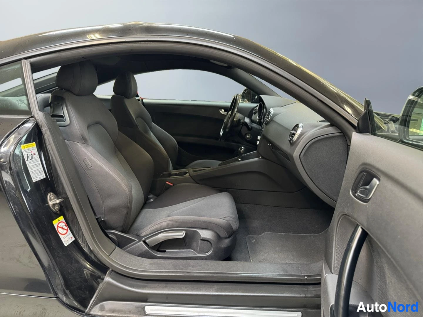 Muu: Audi TT:n sisätila matkustajan puolelta katsottuna: kaksi etuistuinta ja kojelauta.