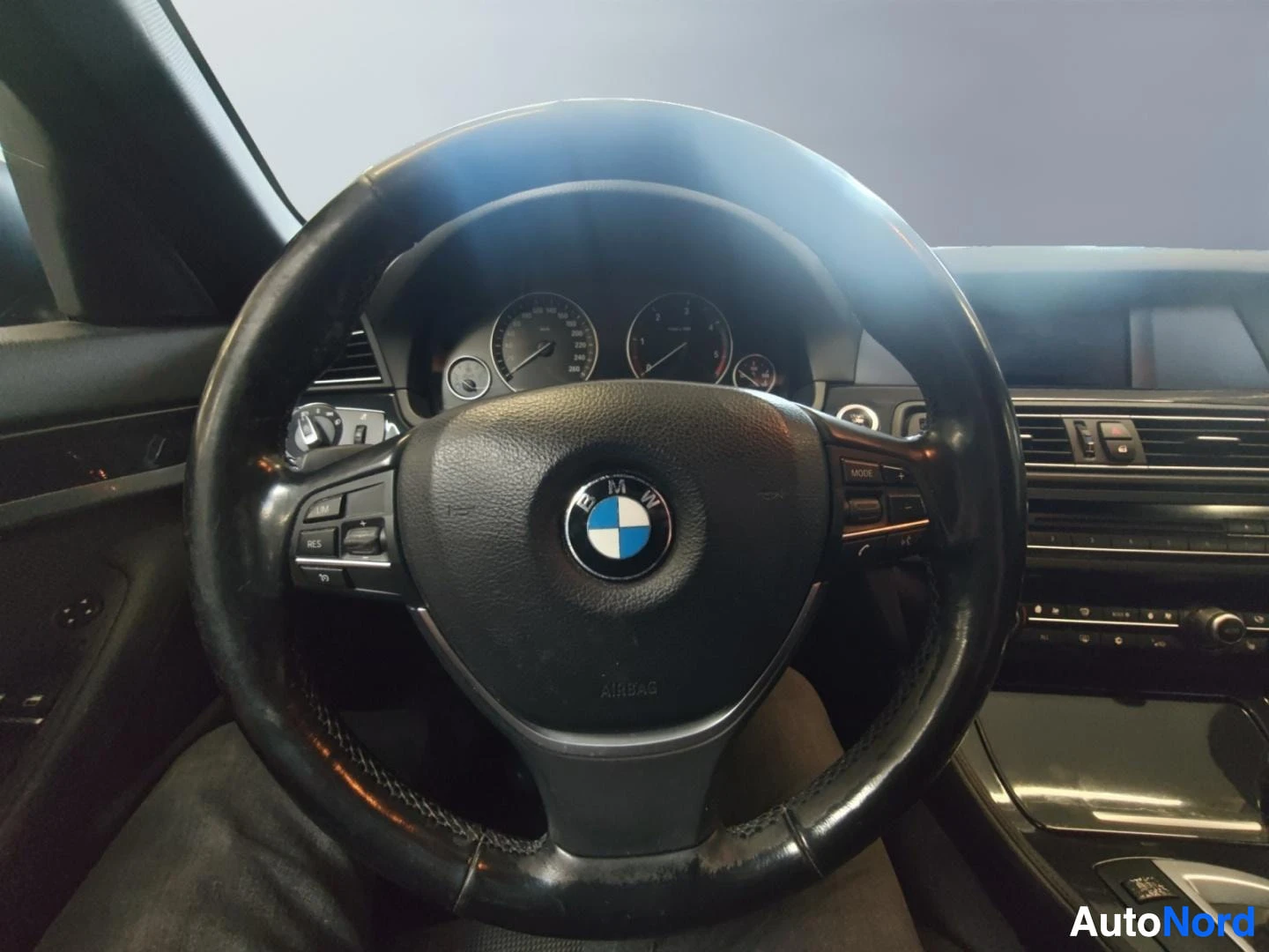 Muu: Ohjaamosta kuva: BMW-ohjauspyörä, kojelauta ja osa keskiöstä.