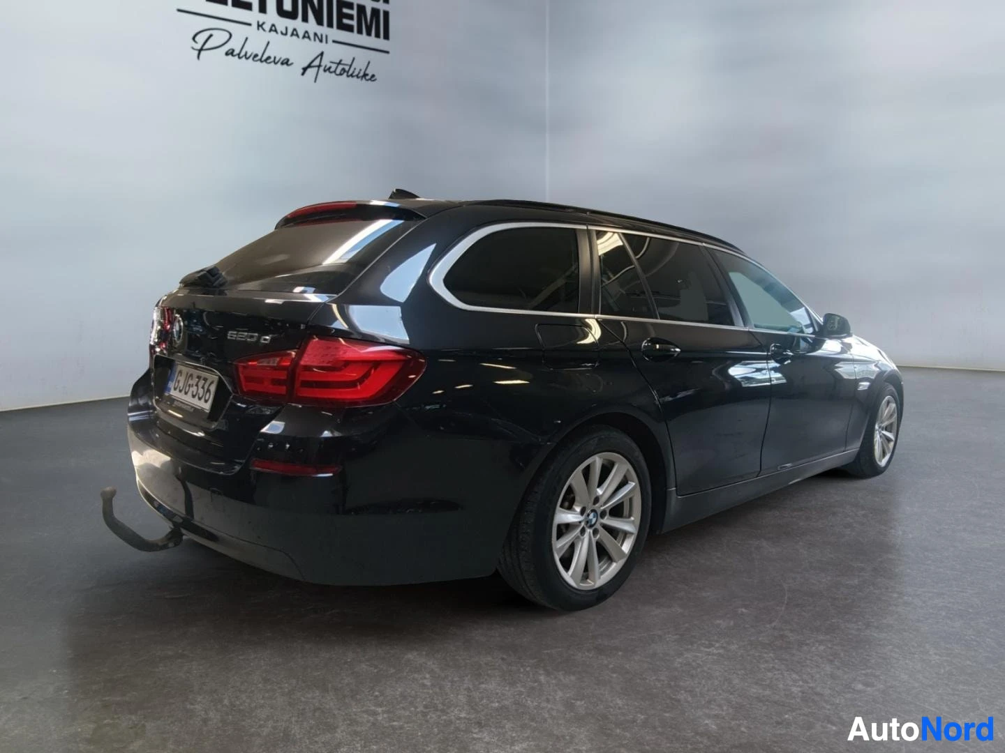 Takaviisto: Musta BMW-farmari takakolmanteesta rekisterikilpi ja vetoaisa