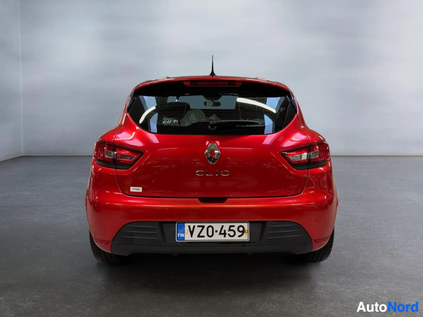 Takaa: Punaisen Renault Clion suora takakuva, rekisterikilpi.