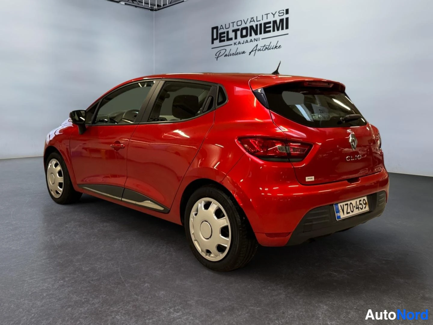 Takaviisto: Punainen Renault Clio takaviistosta; takavalot, portti ja rekisteritunnus näkyvissä.