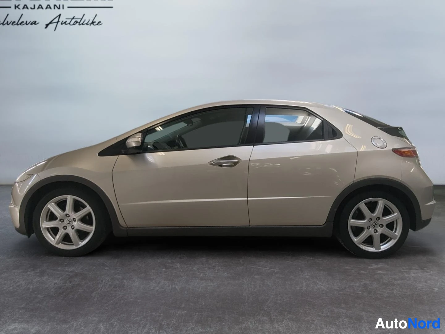 Sivulta: Honda Civic Viistoperä sivulta kuvattuna, beige-kultainen koripelti ja viisiokuvioiset alumiinivanteet.